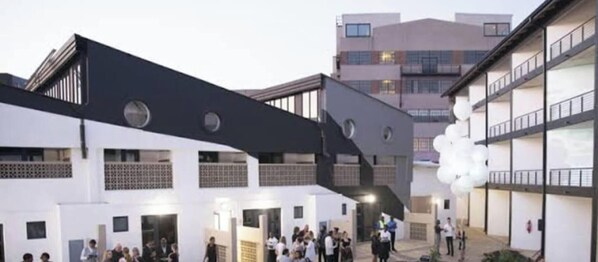 Un edificio moderno con un diseño arquitectónico único, que presenta una paleta de colores blanco y negro y varios niveles.