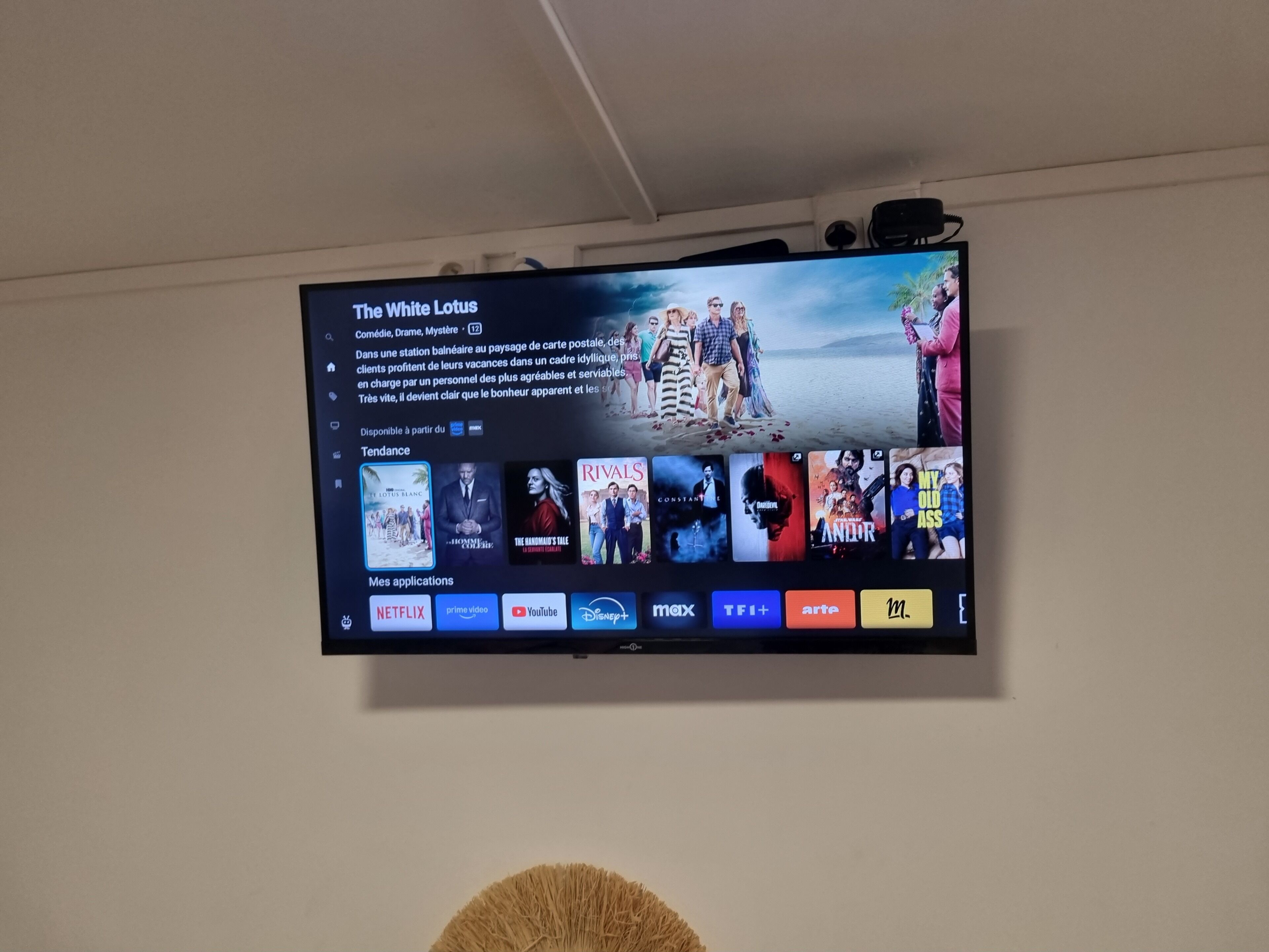 Un téléviseur fixé au mur affiche un écran de sélection de films.