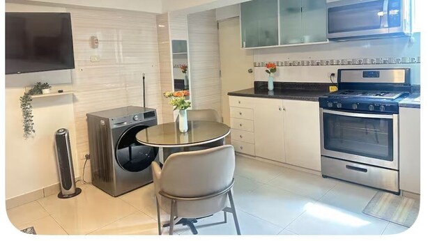 Een moderne keuken met een inbouwoven, een fornuis en een wasmachine.