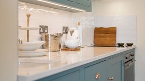 A kitchen with teal cabinets, a white countertop, and a stainless steel range hood. - Beautiful One BD Cottage Near Burford (Burford)