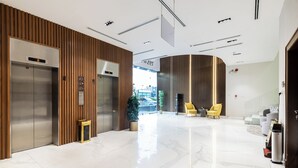 Un vestíbulo moderno con ascensores, una recepción y una zona de estar.