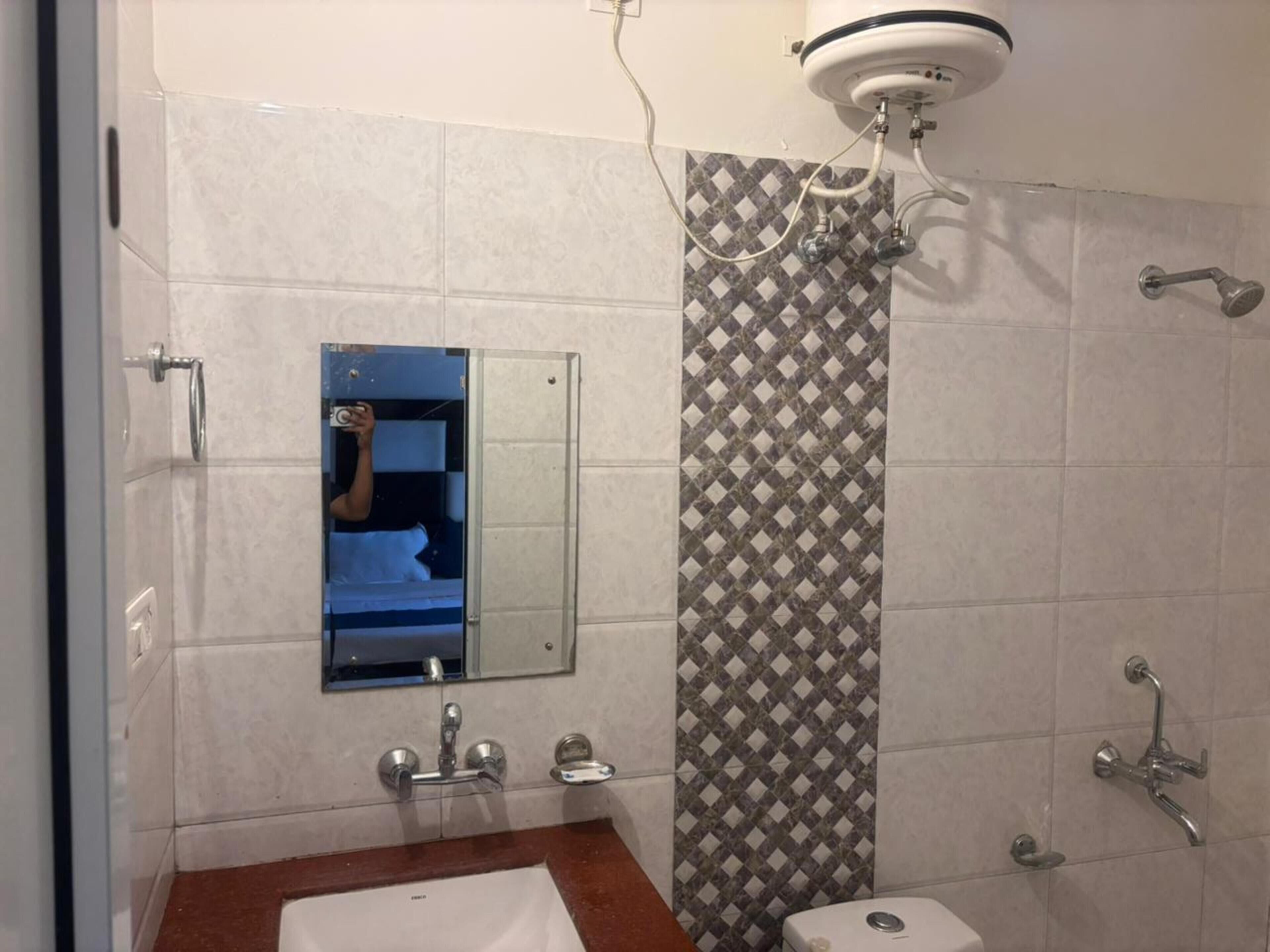 Une salle de bain équipée d’une douche, d’un lavabo, de toilettes et d’un miroir.