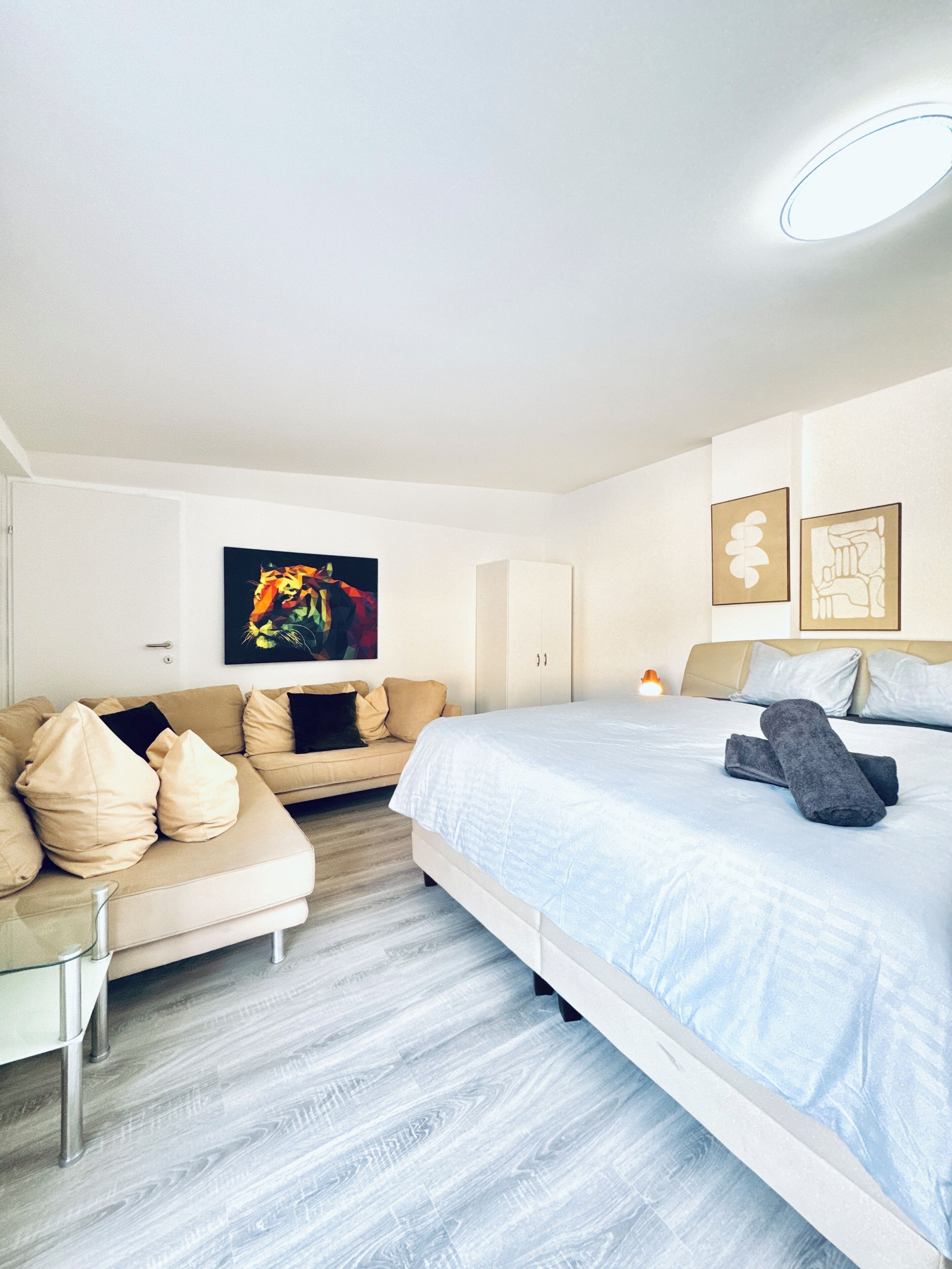 Et moderne hotelværelse med seng, sofa og kunst på væggene.