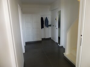 A hallway with a white door, a coat rack, and a white telephone. - Beautiful apartment 100m from the beach, air conditioning, parking, 53m2, balcony and terrace. (Cannes)