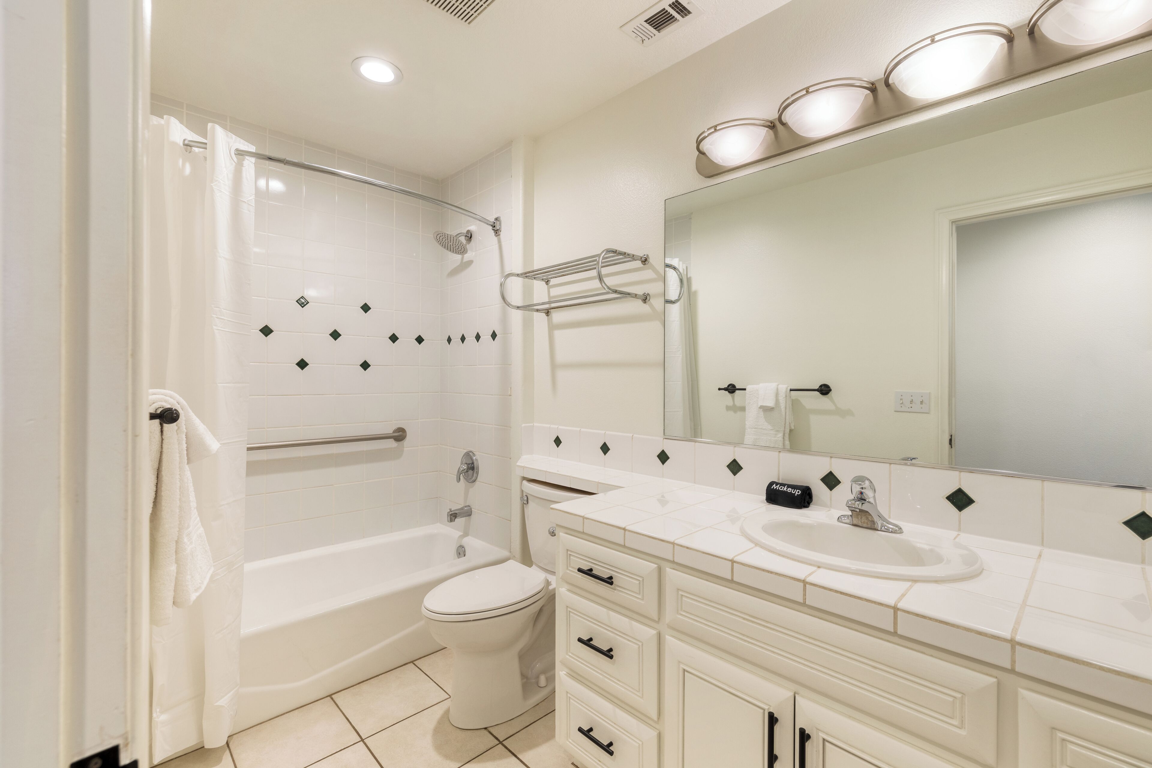 A modern bathroom with a bathtub, toilet, and vanity with a sink.