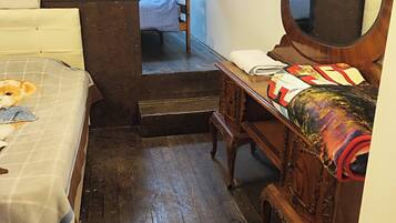 Un dormitorio con cama, cómoda, espejo y una escalera que lleva a otra habitación.