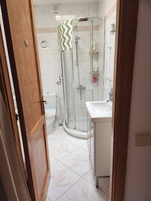 A bathroom with a glass-enclosed shower, a toilet, and a sink. - Casa Del Sol Rio in Costa Calma (Pajara)