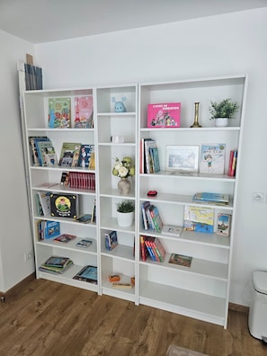 Ein weißes Bücherregal mit verschiedenen Büchern und Dekorationselementen.