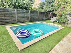 A rectangular swimming pool with two inflatable rings, surrounded by artificial grass and a wooden fence. - Pool villa near Cassis 8/9 sleeps Roquefort-La-Bédoule (Roquefort-la-Bédoule)