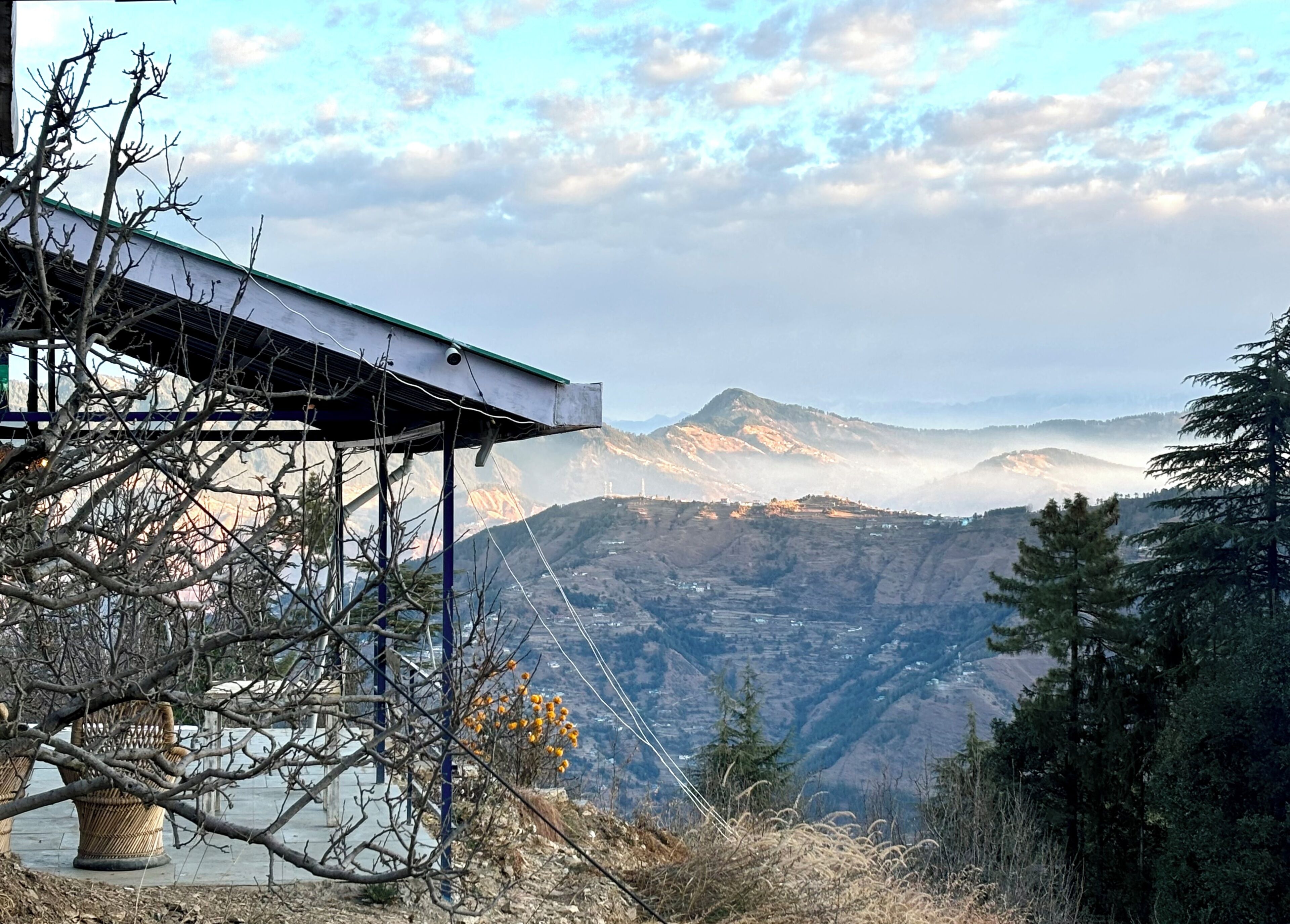 Paisagem montanhosa com uma construção, um telhado e uma câmera.