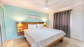 Een slaapkamer met een bed, nachtkastjes, een plafondventilator en een kunstwerk aan de muur.