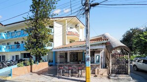 A building with a sign 'EUROPA EUROPA' and a covered outdoor seating area with chairs. - Cheap Hotel Room in Sosua Center! (Sos úa)