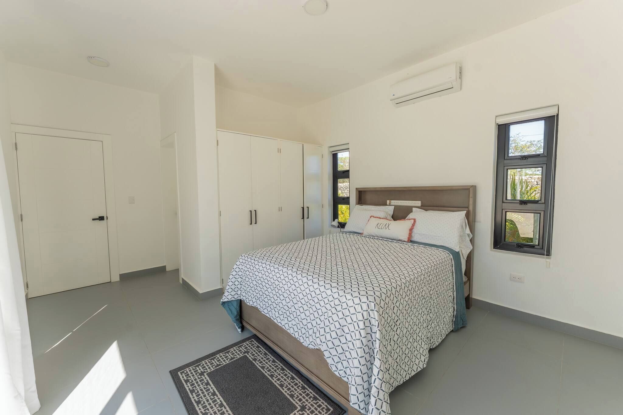 A bedroom with a bed, wardrobe, and a window.