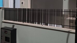 A building exterior with a metal fence, a garage door, and a utility box. - Cozy Apartment in Nea Ionia Greece with Modern Amenities (Nea Ionia)