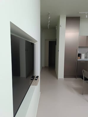 Eine moderne Küche mit Einbauofen, Mikrowelle und Kaffeemaschine. Es gibt eine kleine Sitzecke mit einem Stuhl und einem Tisch.
