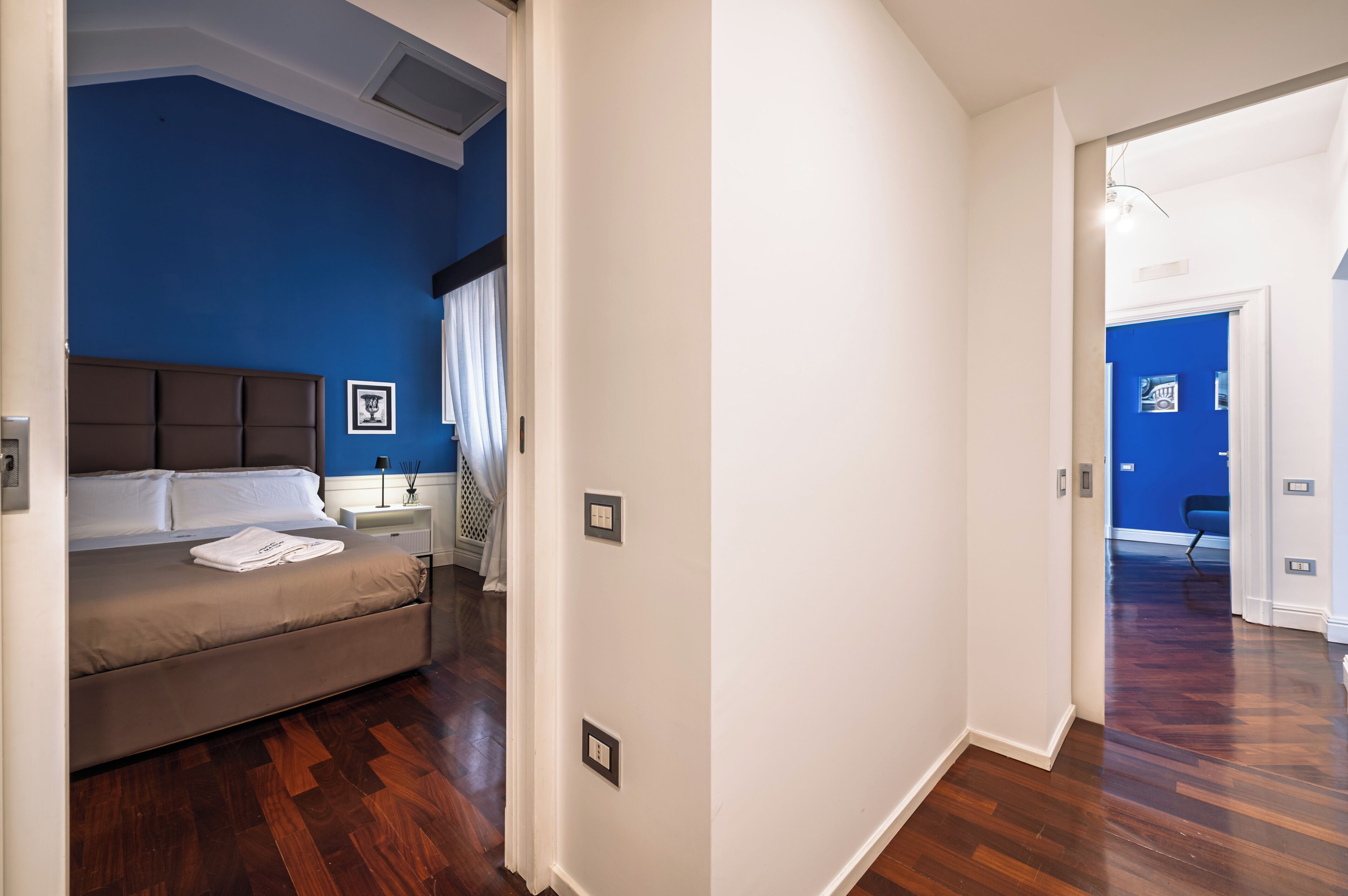 Un dormitorio con cama, mesita de noche y velador.