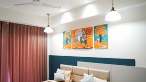 Un dormitorio con cama, cortinas, ventilador de techo, decoración en la pared y una lámpara.