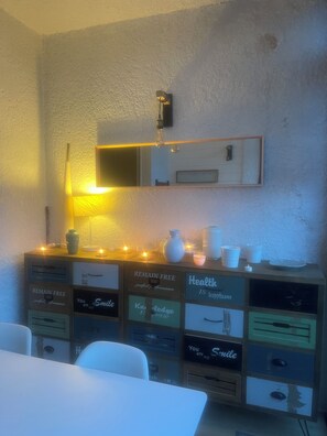 Ein Zimmer mit Schreibtisch, Spiegel und einer Kommode.