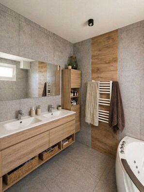 Un bagno moderno con doppio lavabo, un grande specchio, una parete d'accento in legno, un porta asciugamani e una vasca da bagno.