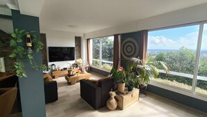 A modern living room with a large TV, comfortable seating, and a view of the outdoors. - Villa Ventoux - 100% Private - 2 steps from Avignon (Villeneuve-lès-Avignon)