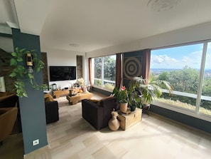 A modern living room with a large TV, comfortable seating, and a view of the outdoors. - Villa Ventoux - 100% Private - 2 steps from Avignon (Villeneuve-lès-Avignon)
