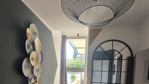 A staircase with a modern design, a wall-mounted decorative light fixture, and a view through an open door. - Villa Ventoux - 100% Private - 2 steps from Avignon (Villeneuve-lès-Avignon)