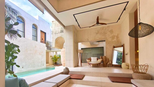 Un interior moderno con piscina, zonas de estar y vistas al exterior.
