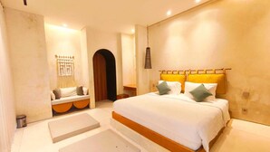 Un dormitorio con una cama grande, una mesita de noche, un banco y una puerta que da a otra habitación.