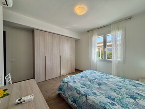 Ein Schlafzimmer mit einem Bett, einem Schreibtisch, einem Stuhl und einem Kleiderschrank.