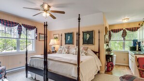 A four-poster bed with a ceiling fan, a window with plaid curtains, and a kitchen area with a sink and cabinets. - Pool Access! Cozy Couple's Getaway in Kilmarnock (Kilmarnock)
