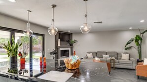 Een moderne keuken met een marmeren aanrecht, hanglampen en een groot eiland.
