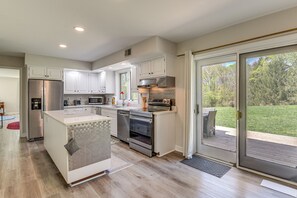 A modern kitchen with white cabinetry, stainless steel appliances, and a large island. - Lush & Secluded Family Getaway in Woodbine (Woodbine)