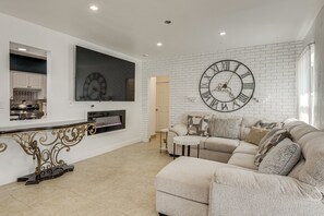 Ein modernes Wohnzimmer mit einer großen Wanduhr, einem Sofa und einem Fernseher.