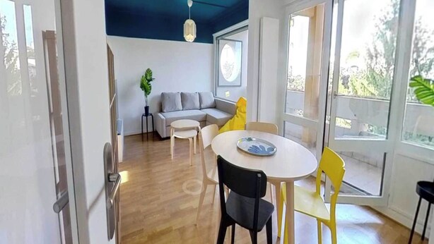 Un espacio moderno para vivir con comedor, sofá y ventanas amplias.