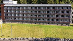 A multi-story building with a uniform facade, a flat roof, and a stone base. - 2 Person Holiday Park Home in Erlbach (Markneukirchen)