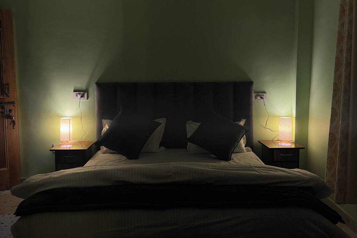 Une chambre à coucher avec un lit, deux lampes de chevet et une table de chevet.