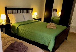 A hotel room with a bed, a nightstand, a lamp, and a mirror. - Apartment Sleeps 6 With Parking (Trapani)