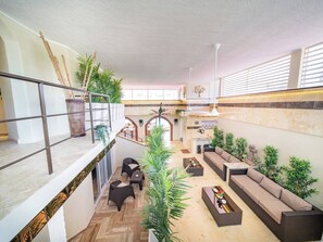 A spacious indoor area with a high ceiling, multiple seating arrangements, and a variety of potted plants. - Luxury 6 Bedroom Villa in Sosua Beachfront Bliss Awaits (Sosúa)