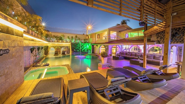 Un área de piscina con sillones de descanso y un bar.