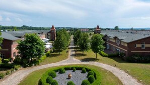 A large building complex with multiple brick structures, a central pathway, and surrounding greenery. - 4 Person Holiday Park Home in Sagad (Sagard)