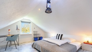 A bedroom with a bed, a desk, a chair, a window, and a ceiling light. - Mareile: Vacation home for 6 people with terrace, WLAN and garden, 900 m to the sea (Uelvesbüll)