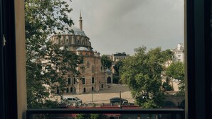 Blick durch ein Fenster auf ein Gebäude mit Kuppel, eine Straße mit Autos und eine Fußgängerampel.