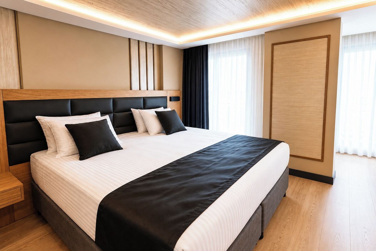 Una habitación de hotel moderna con una cama grande, cabecero de madera y piso de madera.