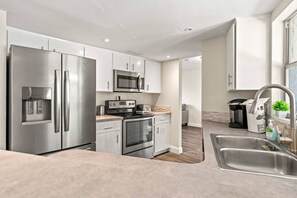 A modern kitchen with stainless steel appliances, a microwave, a toaster, and a sink. - Siesta Key Pool BBQ Mini Putt 3BR 2BA Sleep 12 (Palmetto)