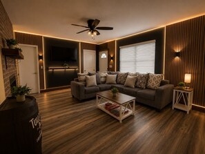 Un salon moderne avec un canapé, une table basse et un téléviseur.