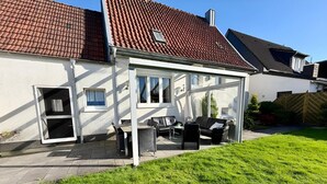 Talo, jossa on patio, ovi ja ikkuna.