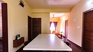 Una larga mesa de comedor con sillas, un banco de madera y una planta pequeña.