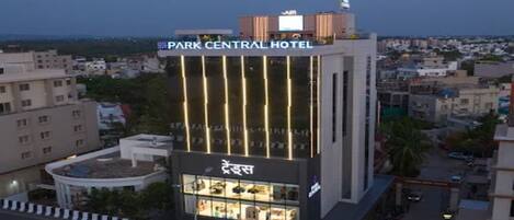 Un hotel de varios pisos con un letrero llamativo que dice 'Park Central Hotel' y un escaparate visible con la leyenda 'Trends'.