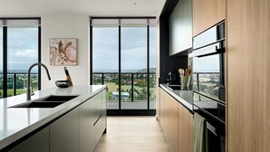 A modern kitchen with a large window, a sink, and a view of the city. - Elevated 3BR Stay - Views, Amenities, Parking (Newcastle West)