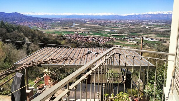 Un balcon avec vue sur la ville, les montagnes et une rivière.